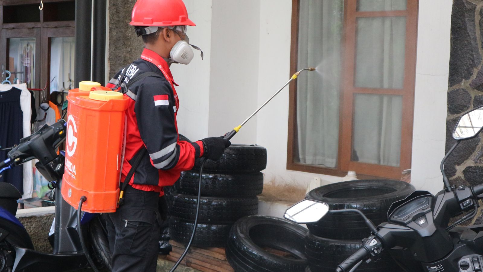 Operario con equipo de protección aplicando tratamiento sanitario